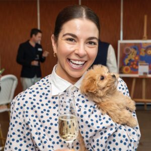 PetAds Unleashed attendee enjoying a networking moment with a puppy at the Melbourne event.