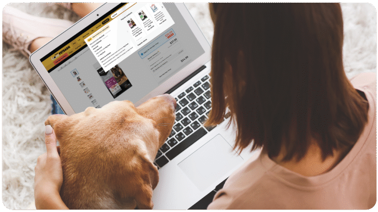 Pet parent browsing sponsored product ads on the Petbarn website while shopping online at home with their cat