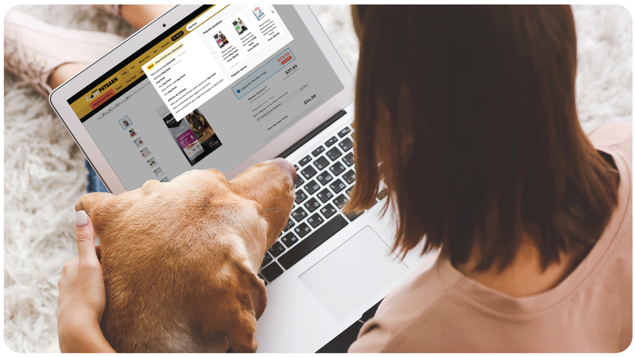Pet parent browsing sponsored product ads on the Petbarn website while shopping online at home with their cat